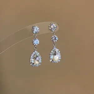 Macro detail of elegant silver-toned pear-shaped drop earrings with sparkling diamond-like crystals