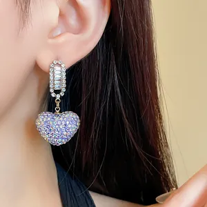 Gros plan de boucles d'oreilles pendantes élégantes en zircon en forme de cœur