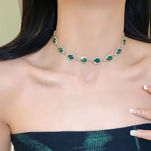 Elegant emerald green waterdrop necklace with silver rhinestone detailing on model