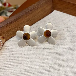 Elegant matte silver flower stud earrings featuring a retro brown stone center design