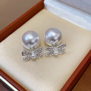 Elegant French vintage earrings featuring large pearls and diamond-studded bow details.