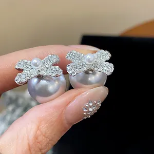 Close-up of elegant French retro bow-knot pearl stud earrings with rhinestones
