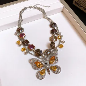 Close-up of a vintage multi-layered necklace featuring an ornate rhinestone butterfly pendant.