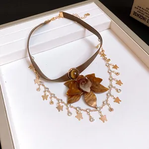 Close-up detail of vintage choker with amber flower pendant and butterfly charms