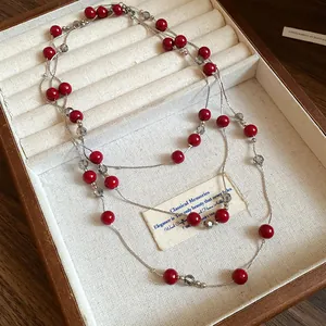 Close-up of retro multi-strand necklace with red and grey beads in a jewelry box