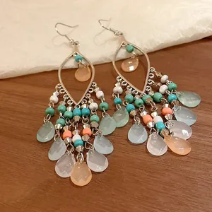Primer plano de pendientes boho retro con detalles de gotas y cuentas coloridas.