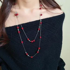 Elegant double-layered long sweater necklace featuring vibrant red and subtle grey beads.