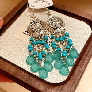 Vista detallada de aretes bohemios con cuentas turquesas y colgantes de gotas de agua