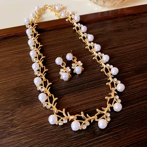 Detail view of a French luxury faux pearl and crystal jewelry set on a wood tray