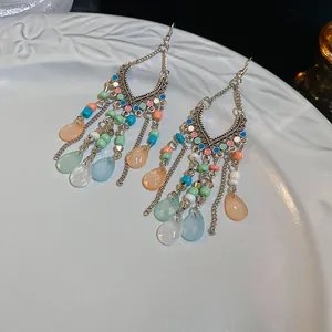 Vista detallada de pendientes largos bohemios con cuentas de colores y colgantes