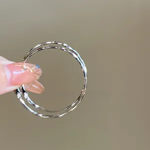 Primo piano di grandi orecchini a cerchio argento con elegante finitura martellata.
