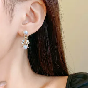 Elegant close-up shot of pearl drop earrings with sparkling rhinestones on a woman's ear