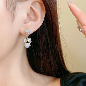 Close-up of elegant French style gold earrings with pearls and rhinestones