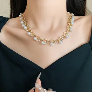 Detail view of elegant gold vine necklace with faux pearls and rhinestones on neck