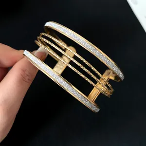 Detailed close-up of multi-layer gold cuff bracelet with sparkling silver glitter finish