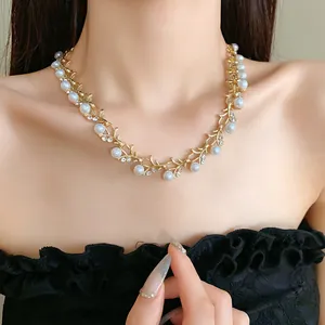 Detail view of French style gold-tone necklace with pearls and rhinestones on model