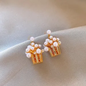 Close-up detail of 18K gold plated flower basket earrings with pearls and zircons
