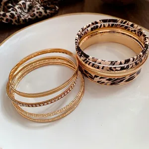 Elegant vintage metal and leopard print bangle set with rhinestone accents on a plate