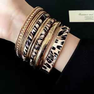 Exquisite stack of leopard print leather and gold-tone metal bracelets with rhinestones