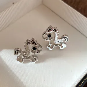 Exquisite silver-toned horse stud earrings featuring black crystal eyes in a white jewelry box