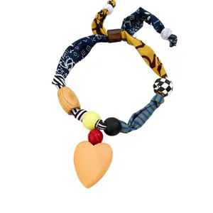 Chic vintage fabric and wood bead necklace featuring a large peach heart-shaped pendant.
