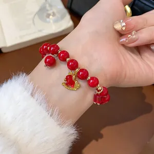 Detailed view of fashion red beaded bracelet with exquisite gold horse charm on wrist