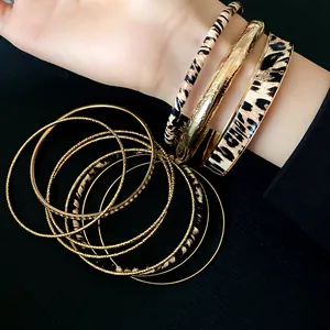 Detailed macro shot of vintage leopard print leather and gold textured metal bracelet set