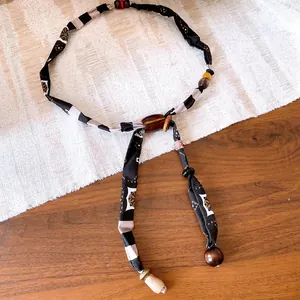 Macro detail view of vintage fabric and wood bead necklace with warm Maillard tones