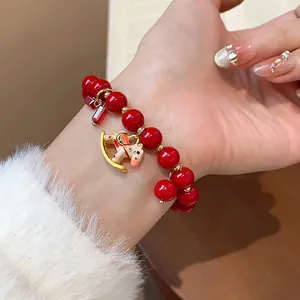 Detail view of a vibrant red beaded bracelet with an enamel rocking horse charm.