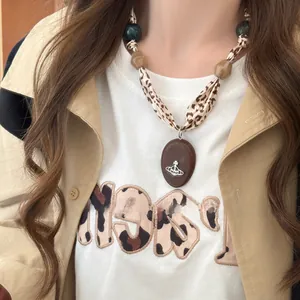 Retro leopard print silk scarf necklace with vintage beads and metallic orb pendant detail