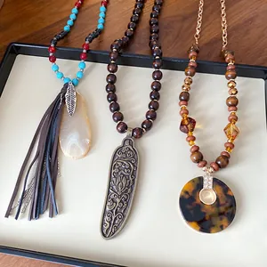 Boho necklace collection featuring wood beads, tassel, and engraved metal pendant