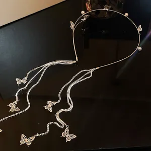 Vue détaillée d'un élégant serre-tête papillon doré avec perles et longues chaînes