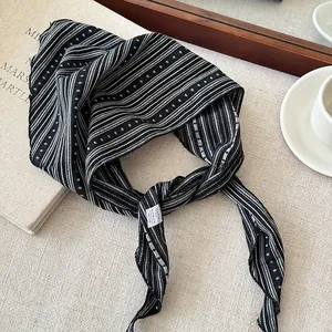 Detailed macro view of a black and white striped fabric headband with elegant dotted patterns.