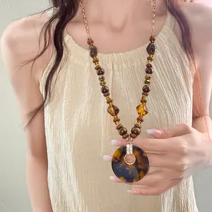 Detail view of a vintage ethnic necklace with wooden beads and a tortoiseshell pendant