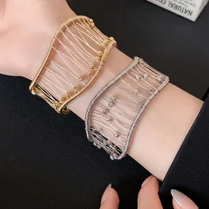 Close-up detail of vintage French gold and silver woven mesh open cuff bracelets on model