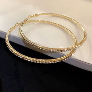 Elegant oversized gold-tone hoop earrings adorned with sparkling pavé rhinestones