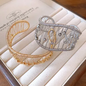 Close-up detail of vintage woven hollow mesh open bangles in gold and silver