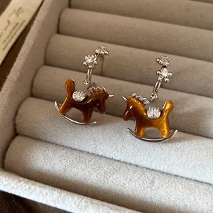 Elegant silver needle rocking horse pendant earrings with brown shimmer and diamond accents