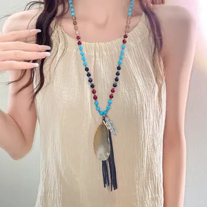 Detailed view of bohemian beaded necklace with agate pendant on model.