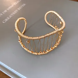Close-up of French vintage woven gold cuff bracelet featuring an intricate hollow mesh design