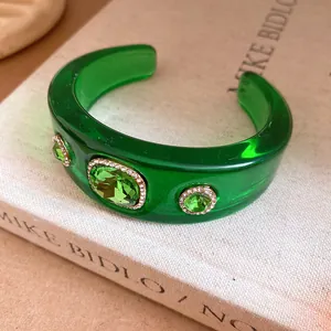 Detailed macro shot of a green resin cuff bracelet with sparkling crystal accents