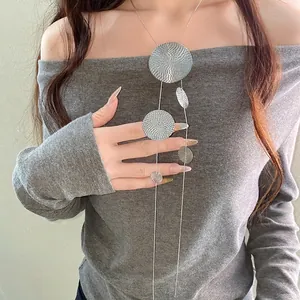 Collier long à pampilles argentées avec pendentifs ronds sur un mannequin.