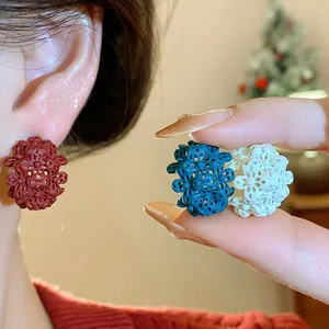 Vista dettagliata di orecchini a fiore in argento s925 nei colori rosso, teal e bianco