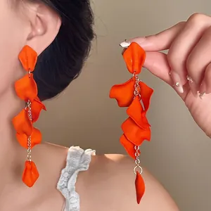 Vibrant orange petal tassel drop earrings with bohemian flair on model