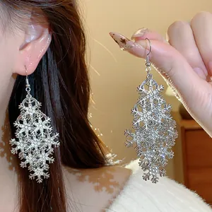Gros plan de boucles d'oreilles pendantes flocon de neige à strass sur modèle