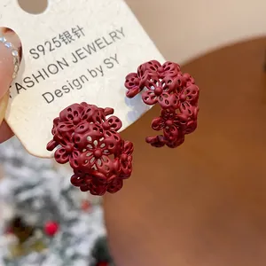 Vista dettagliata di orecchini a perno vintage bordeaux a forma di C con fiori traforati