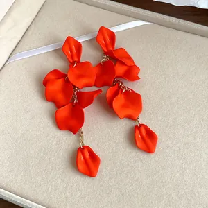 Macro detail of vibrant orange layered petal tassel earrings, bohemian style jewelry