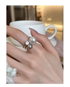 Dettaglio di un elegante anello aperto in stile francese con perle e uno zircone