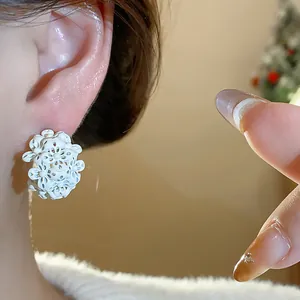 Dettaglio di orecchini vintage a forma di fiore a C con petali bianchi e ago d'argento
