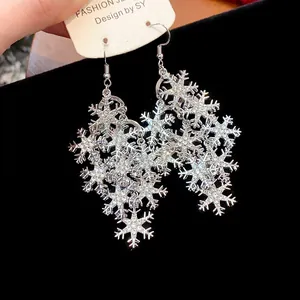 Vue détaillée de boucles d'oreilles flocon de neige avec strass brillants et argent